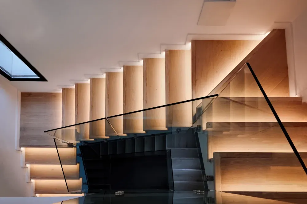 Floating staircase with LED step lighting and a glass rail
