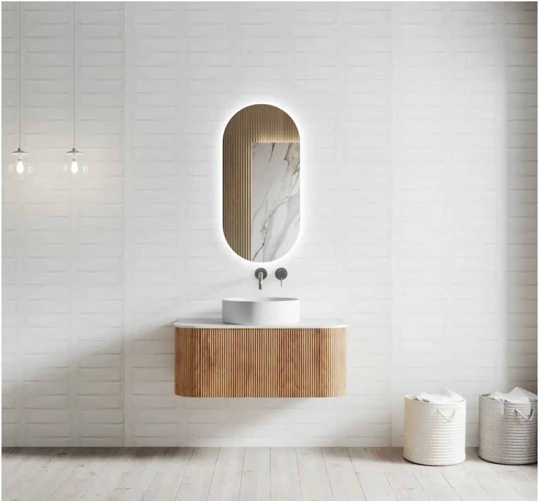Curved floating wood vanity under a backlit pill-shaped mirror