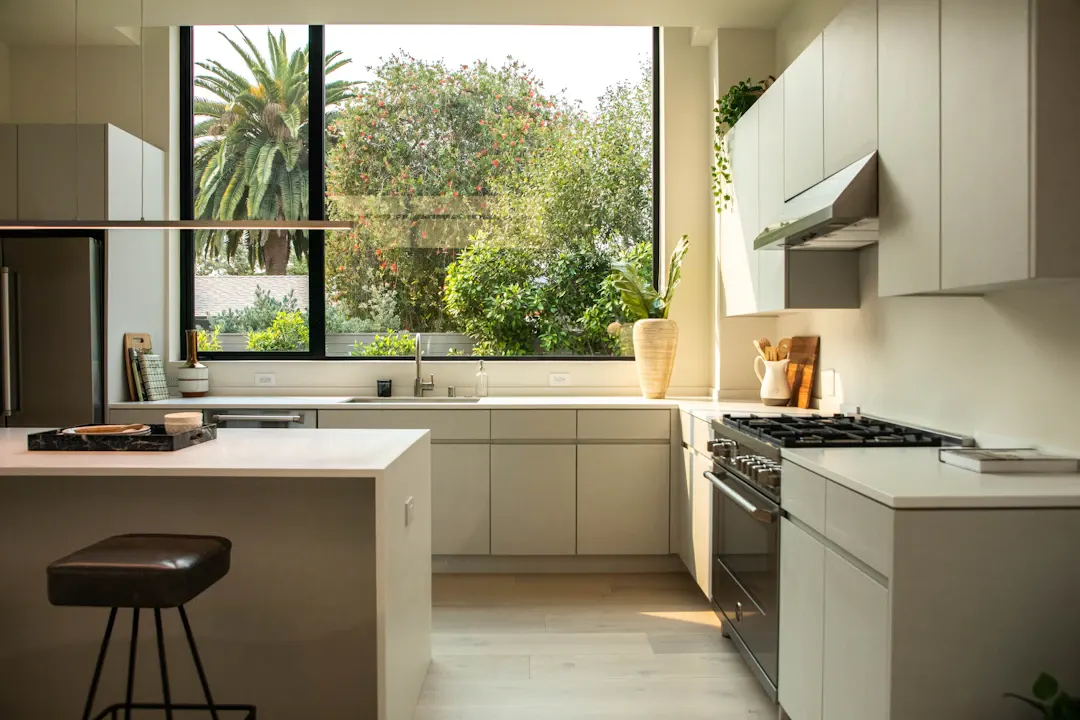 Kitchen with gray flat-panel cabinets beside a large window