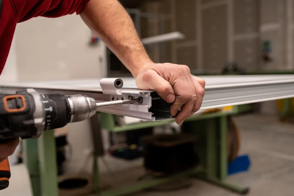 Installer mounting a drawer slide with a drill