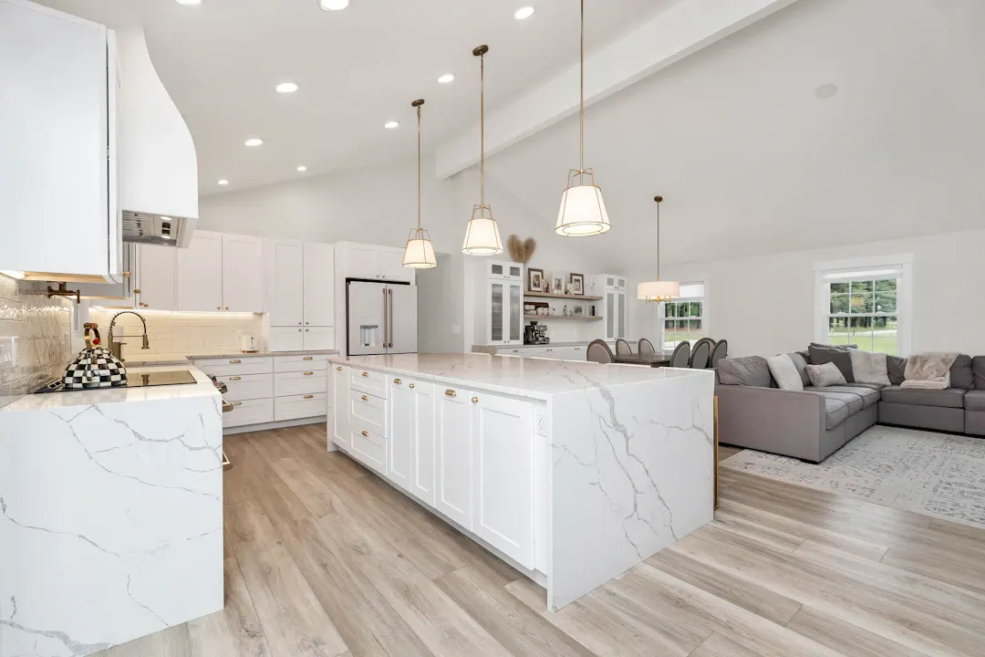 Kitchen with a marble waterfall island and pendant lights