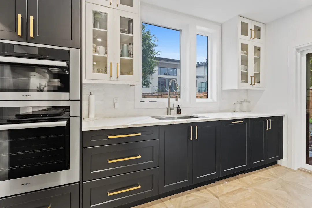 Navy lower cabinets with a white countertop and gold pulls