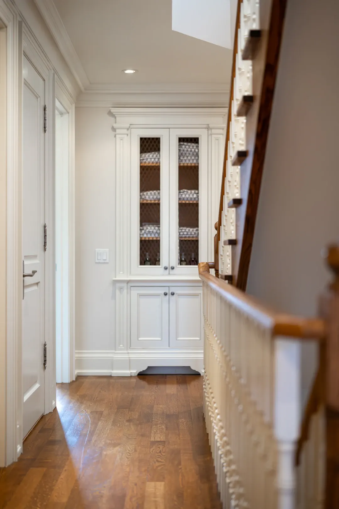 Painted built-in cabinetry with trim beside a staircase