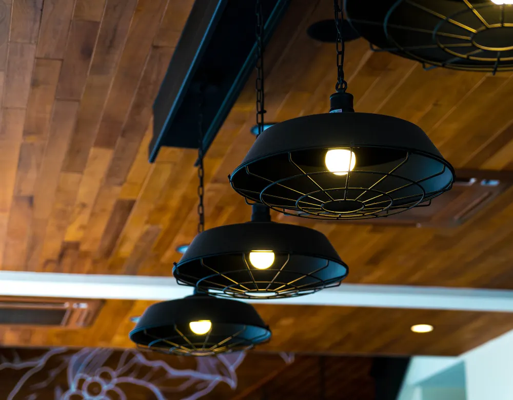 Black pendant lights hanging from a wood ceiling