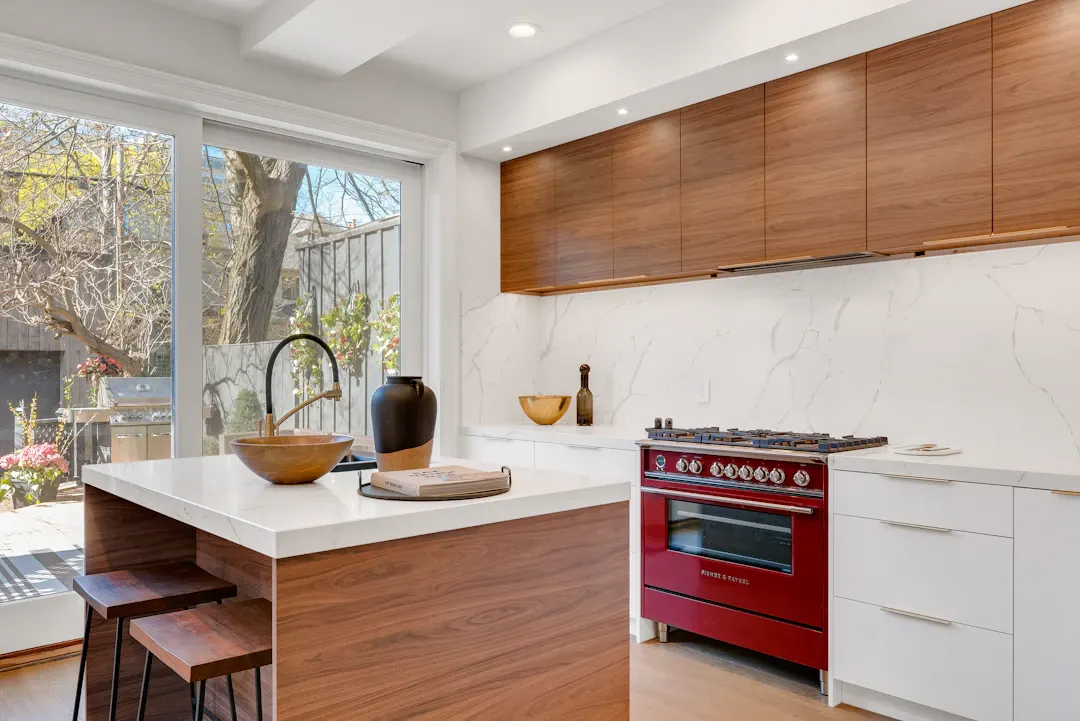 Kitchen with walnut upper cabinets and a red range