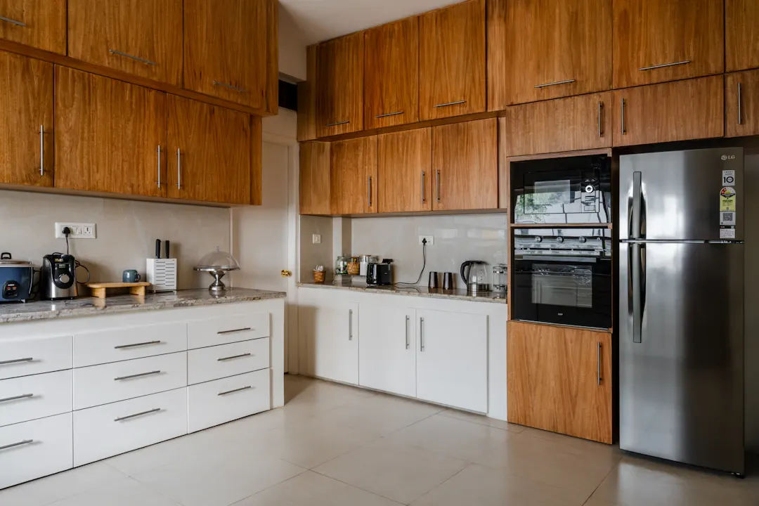 Kitchen with warm walnut upper cabinets, white lowers and stainless appliances