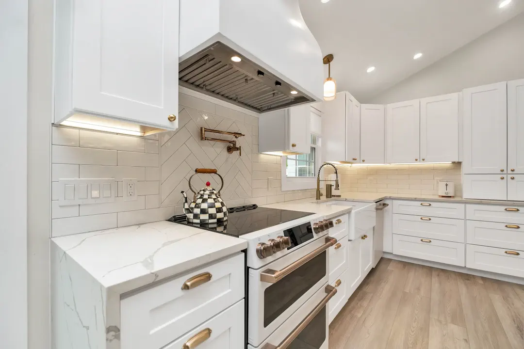 White kitchen with brass hardware and under-cabinet lighting
