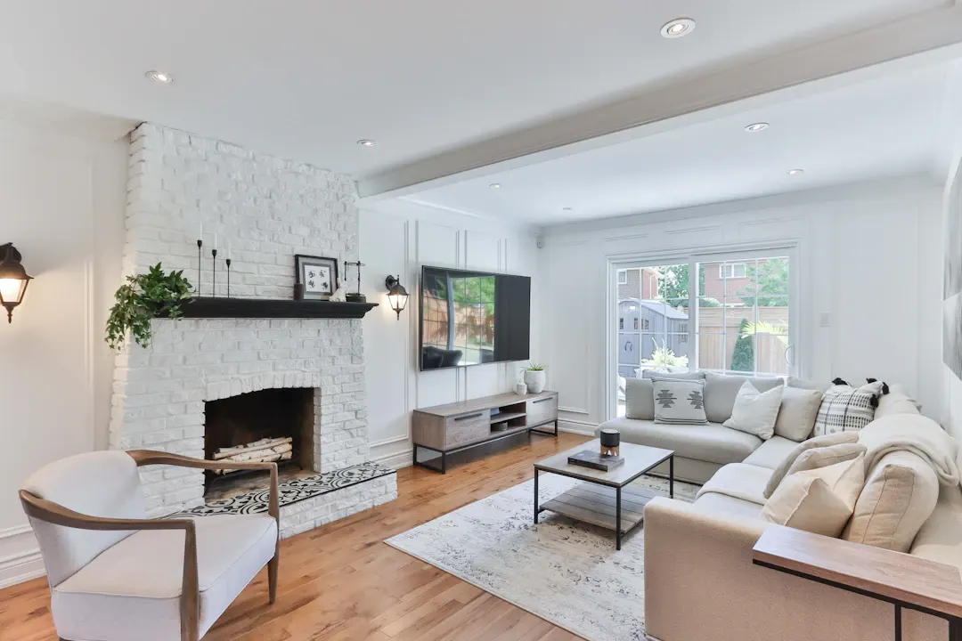 White living room with a brick fireplace and media wall