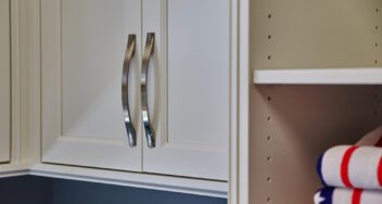 White custom cabinet doors with curved metal handles by Ace Kustoms Cabinets & Trim